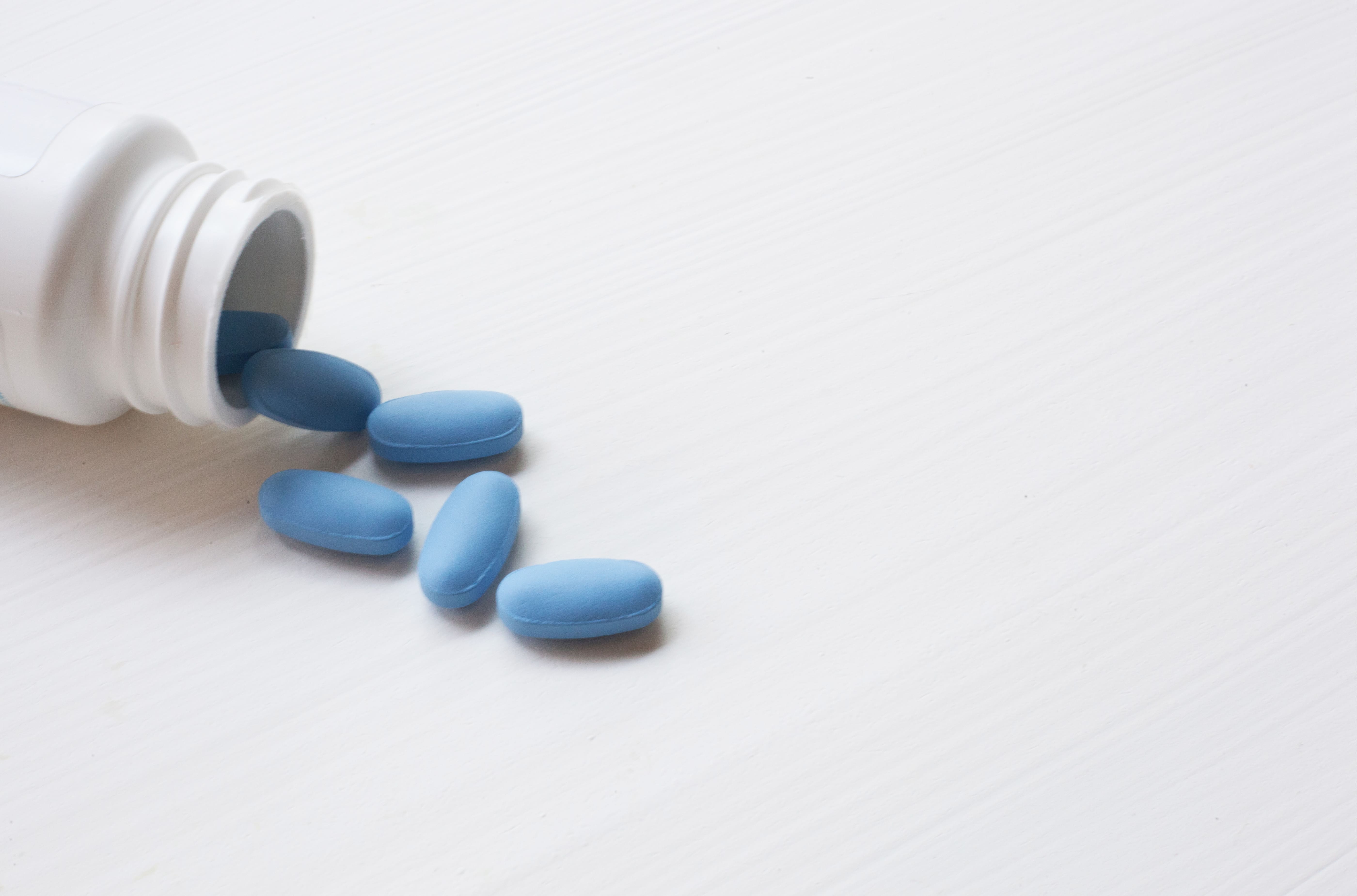 Image blue pills spilling from white medicine bottle 2026 03 25 08 25 16 utc (1)
