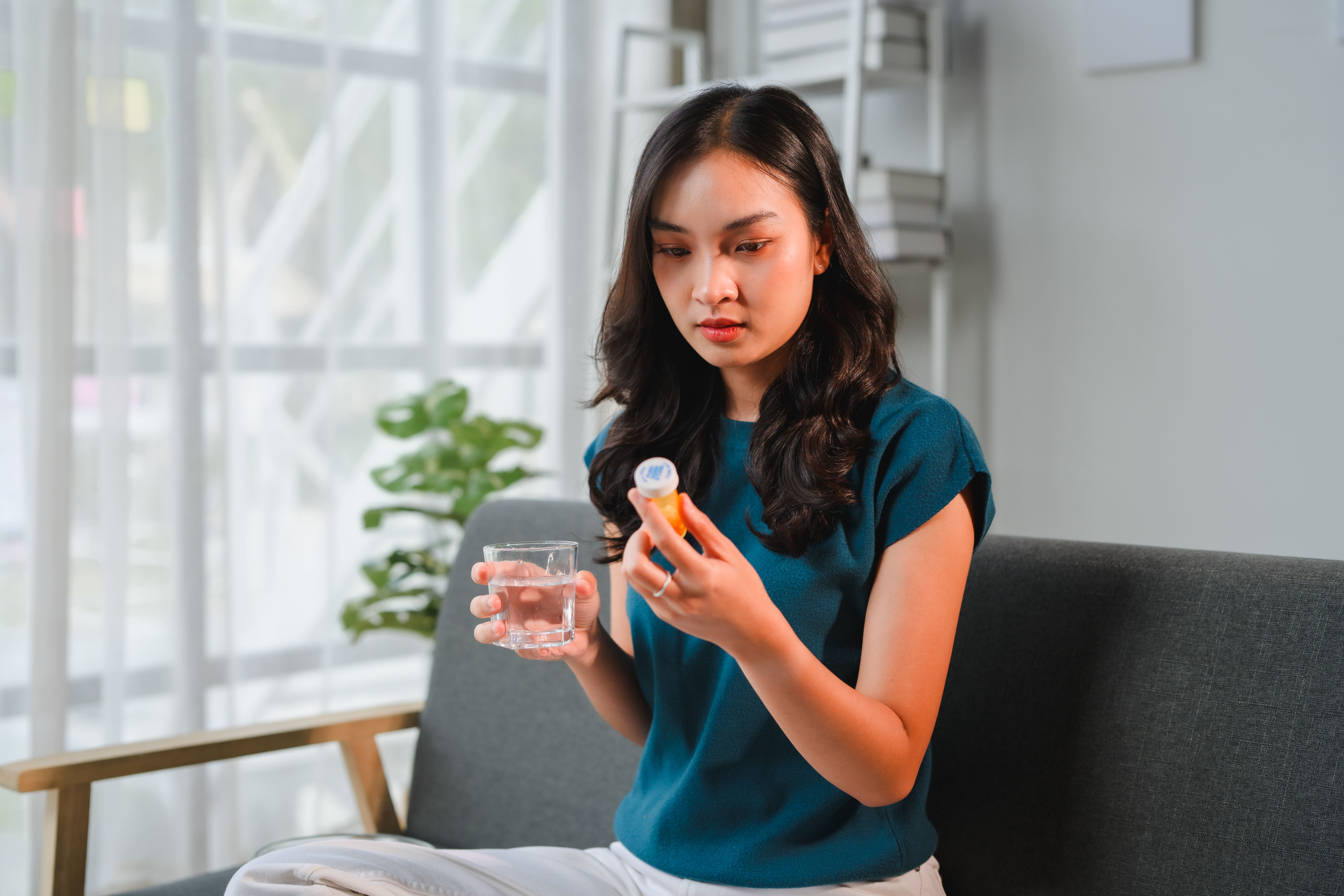 Image woman with pills and water at home 2026 01 09 00 01 18 utc (1)